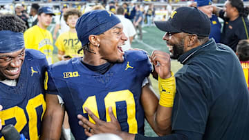 Michigan head coach Sherrone Moore, right, talks to quarterback Alex Orji (10) and running back Kalel Mullings (20) after 27-24 win over USC at Michigan Stadium in Ann Arbor on Saturday, Sept. 21, 2024.