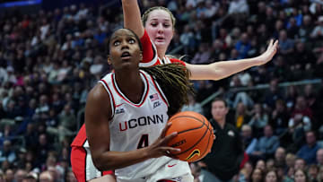 Nov 16, 2025; Hartford, Connecticut, USA; UConn Huskies guard Blanca Quinonez (4) drives the ball against Ohio State Buckeyes forward Kylee Kitts (1) in the first half at Peoples Bank Arena. Mandatory Credit: David Butler II-Imagn Images
