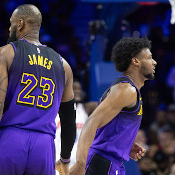 Jan 28, 2025; Philadelphia, Pennsylvania, USA; Los Angeles Lakers forward LeBron James (23) and guard Bronny James (9) slap hands before a substitution during the fourth quarter against the Philadelphia 76ers at Wells Fargo Center. Mandatory Credit: Bill Streicher-Imagn Images