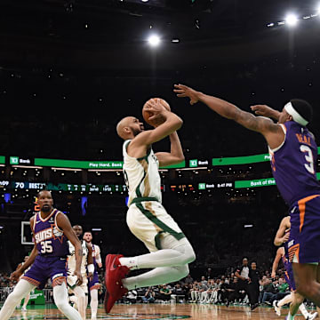 Mar 14, 2024; Boston, Massachusetts, USA;  Boston Celtics guard Derrick White (9) shoots the ball while Phoenix Suns guard Bradley Beal (3) defends during the second half at TD Garden. Mandatory Credit: Bob DeChiara-Imagn Images