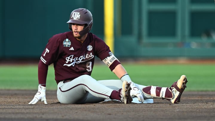 Jun 19, 2024; Omaha, NE, USA; Texas A&M Aggies third baseman Gavin Grahovac (9) sits on the base after being thrown out against the Florida Gators during the second inning at Charles Schwab Field Omaha.