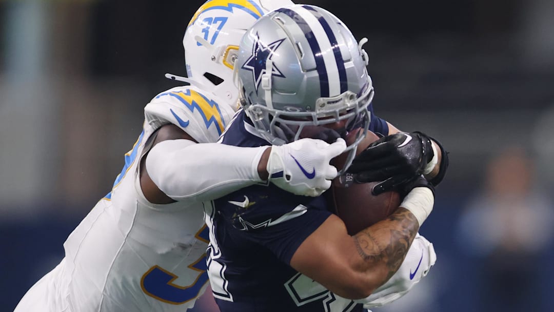  Los Angeles Chargers safety Thomas Harper (37) grabs the facemask of Dallas Cowboys running back Deuce Vaughn (42) in the first half at AT&T Stadium.