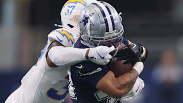  Los Angeles Chargers safety Thomas Harper (37) grabs the facemask of Dallas Cowboys running back Deuce Vaughn (42) in the first half at AT&T Stadium.