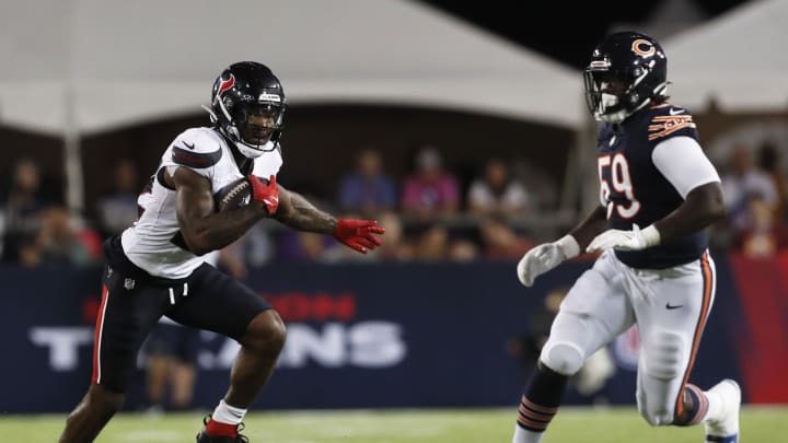 Aug 1, 2024; Canton, Ohio, USA;  Houston Texans running back Cam Akers (22) runs after a catch as Chicago Bears defensive tackle Jamree Kromah (59) chases during the second quarter at Tom Benson Hall of Fame Stadium. Mandatory Credit: Charles LeClaire-USA TODAY Sports