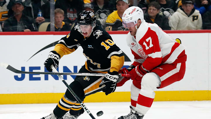 Apr 11, 2024; Pittsburgh, Pennsylvania, USA;  Pittsburgh Penguins left wing Drew O'Connor (10) and Detroit Red Wings right wing Daniel Sprong (17) chase the puck during the third period at PPG Paints Arena. Mandatory Credit: Charles LeClaire-Imagn Images