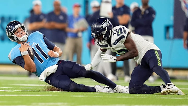 Tennessee Titans quarterback Mason Rudolph (11) collides with Seattle Seahawks safety Marquise Blair (13) during the fourth quarter at Nissan Stadium in Nashville, Tenn., Saturday, Aug. 17, 2024.