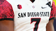 A view of the Mountain West Conference logo on the uniform of San Diego State Aztecs running back Lucky Sutton (7).