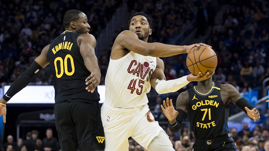 Cleveland Cavaliers guard Donovan Mitchell passes past Golden State Warriors forward Jonathan Kuminga.