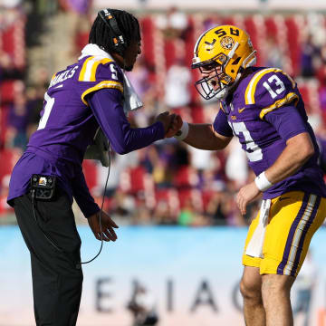 Jan 1, 2024; Tampa, FL, USA; LSU Tigers quarterback Jayden Daniels (5) congratulates quarterback Garrett Nussmeier (13) after  touchdownagainst the Wisconsin Badgers in the fourth quarter during the ReliaQuest Bowl at Raymond James Stadium. Mandatory Credit: Nathan Ray Seebeck-USA TODAY Sports