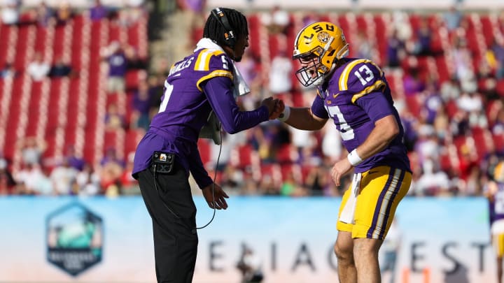 Jan 1, 2024; Tampa, FL, USA; LSU Tigers quarterback Jayden Daniels (5) congratulates quarterback Garrett Nussmeier (13) after  touchdownagainst the Wisconsin Badgers in the fourth quarter during the ReliaQuest Bowl at Raymond James Stadium. Mandatory Credit: Nathan Ray Seebeck-USA TODAY Sports