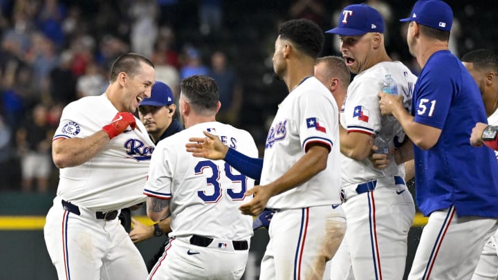 Aug 21, 2024; Arlington, Texas, USA; Texas Rangers left fielder Wyatt Langford (36) and relief pitcher Kirby Yates (39) and second baseman Marcus Semien (2) and first baseman Nathaniel Lowe (30) celebrate after Langford drives in the game winning run by pinch runner Ezequiel Duran (not pictured) against the Pittsburgh Pirates during the ninth inning at Globe Life Field. Mandatory Credit: Jerome Miron-USA TODAY Sports