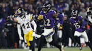 Jan 11, 2025; Baltimore, Maryland, USA; Baltimore Ravens running back Derrick Henry (22) runs for a touchdown against Pittsburgh Steelers cornerback James Pierre (42) in the third quarter in an AFC wild card game at M&T Bank Stadium. Mandatory Credit: Geoff Burke-Imagn Images