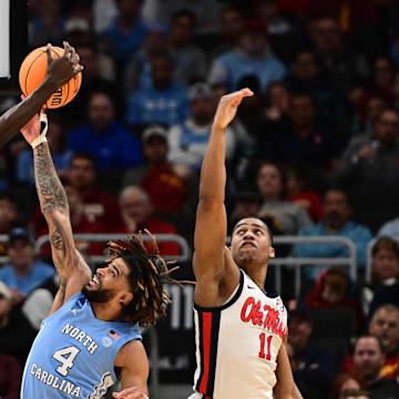 Mar 21, 2025; Milwaukee, WI, USA; North Carolina Tar Heels guard Drake Powell (9) and guard RJ Davis (4) rebound against Mississippi Rebels guard Matthew Murrell (11) during the first half of a first round NCAA men’s tournament game at Fiserv Forum.
