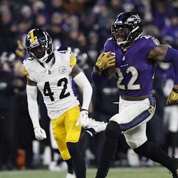Jan 11, 2025; Baltimore, Maryland, USA; Baltimore Ravens running back Derrick Henry (22) runs for a touchdown against Pittsburgh Steelers cornerback James Pierre (42) in the third quarter in an AFC wild card game at M&T Bank Stadium. Mandatory Credit: Geoff Burke-Imagn Images