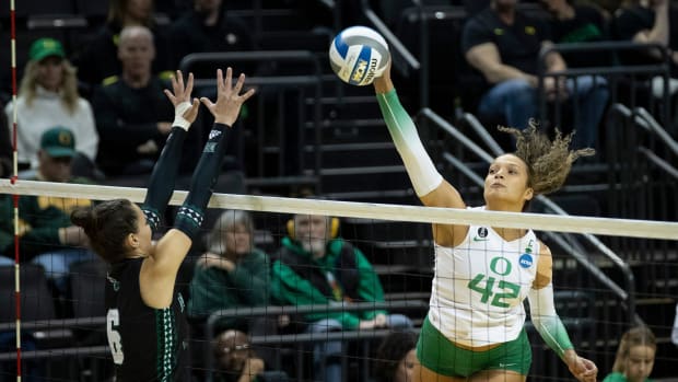 Oregon middle blocker Karson Bacon hits as the No. 2 Oregon Ducks host Hawaii