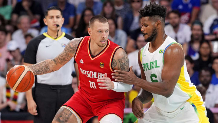 Jul 30, 2024; Villeneuve-d'Ascq, France; Germany power forward Daniel Theis (10) drives to the basket against Brazil centre Cristiano Felicio (6) in men’s basketball group B play during the Paris 2024 Olympic Summer Games at Stade Pierre-Mauroy. Mandatory Credit: John David Mercer-USA TODAY Sports