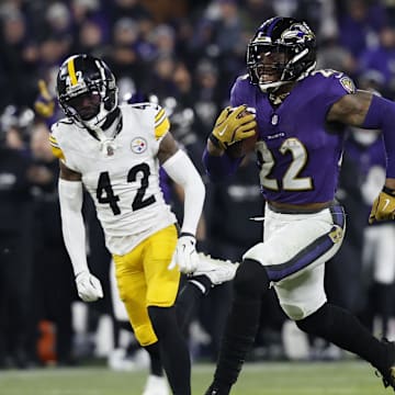 Jan 11, 2025; Baltimore, Maryland, USA; Baltimore Ravens running back Derrick Henry (22) runs for a touchdown against Pittsburgh Steelers cornerback James Pierre (42) in the third quarter in an AFC wild card game at M&T Bank Stadium. Mandatory Credit: Geoff Burke-Imagn Images