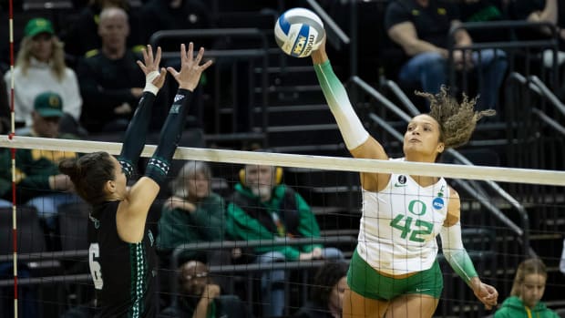 Oregon middle blocker Karson Bacon hits as the No. 2 Oregon Ducks host Hawaii