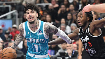 Charlotte Hornets guard LaMelo Ball dribbles the ball past Toronto Raptors guard Immanuel Quickley.