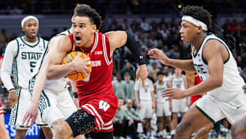 Mar 15, 2025; Indianapolis, IN, USA; Wisconsin Badgers guard John Tonje (9) shoots the ball while Michigan State Spartans guard Jeremy Fears Jr. (1) defends in the second half  at Gainbridge Fieldhouse. Mandatory Credit: Trevor Ruszkowski-Imagn Images