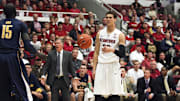 Jan 19, 2013; Stanford, CA, USA; Stanford Cardinal forward Dwight Powell (33) reacts after being fouled by California Golden Bears forward Bak Bak (15) as California Golden Bears head coach Mike Montgomery reacts in the background during the first half at Maples Pavilion. Mandatory Credit: Kelley L Cox-Imagn Images