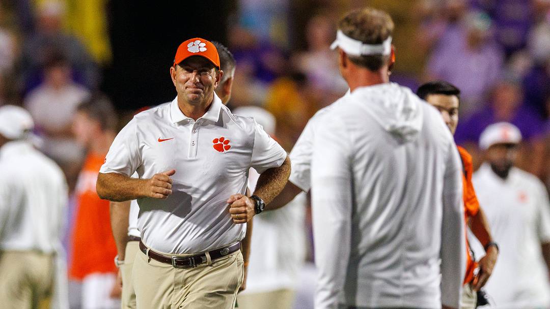 Sep 5, 2026; Baton Rouge, Louisiana, USA;  Clemson Tigers head coach Dabo Swinney runs to greet LSU Tigers head coach Lane Kiffin before a game at Tiger Stadium.  Mandatory Credit: Stephen Lew-Imagn Images