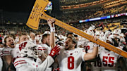 Nov 25, 2023; Minneapolis, Minnesota, USA; Wisconsin Badgers quarterback Tanner Mordecai (8) hoists Paul Bunyan s Axe after defeating the Minnesota Golden Gophers to claim the rivalry trophy at Huntington Bank Stadium. 