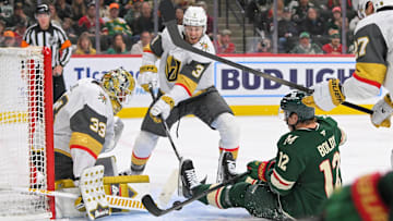 May 1, 2025; Saint Paul, Minnesota, USA;  Vegas Golden Knights goalie Adin Hill (33) makes a save on Minnesota Wild forward Matt Boldy (12) as defenseman Brayden McNabb (3) defends during the second period in game six of the first round of the 2025 Stanley Cup Playoffs at Xcel Energy Center. Mandatory Credit: Nick Wosika-Imagn Images