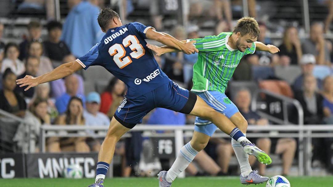 Aug 16, 2025; Saint Paul, Minnesota, USA;  Minnesota United defender Morris Duggan (23) strips Seattle Sounders forward Pedro de la Vega (10) of the ball during the second half at Allianz Field. Mandatory Credit: Nick Wosika-Imagn Images