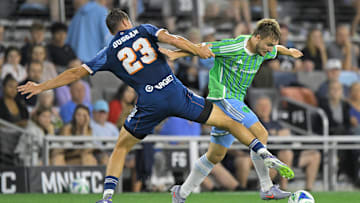 Aug 16, 2025; Saint Paul, Minnesota, USA;  Minnesota United defender Morris Duggan (23) strips Seattle Sounders forward Pedro de la Vega (10) of the ball during the second half at Allianz Field. Mandatory Credit: Nick Wosika-Imagn Images