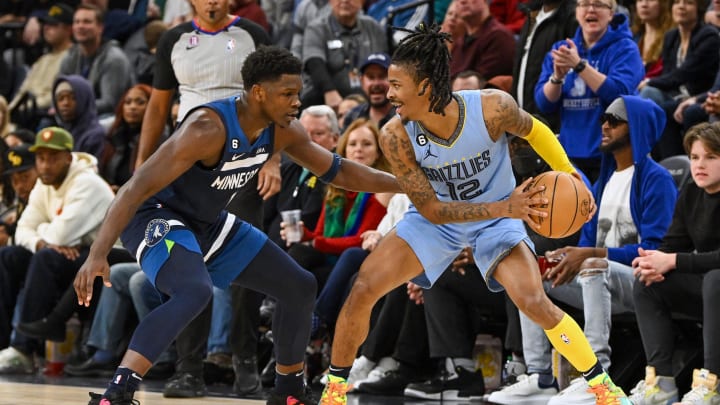 Nov 30, 2022; Minneapolis, Minnesota, USA;  Memphis Grizzlies guard Ja Morant (12) protects the ball as Minnesota Timberwolves forward Anthony Edwards (1) defends during the second quarter at Target Center. 