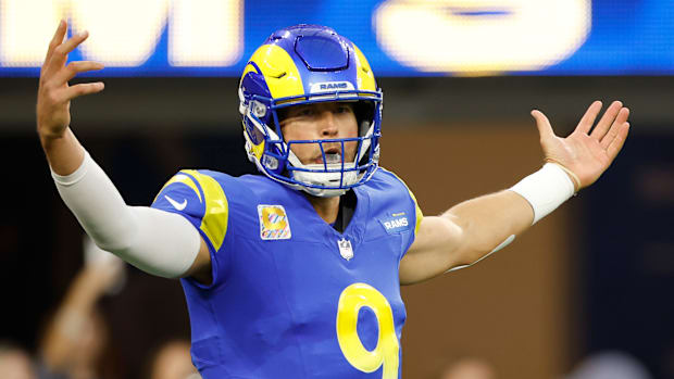 Matthew Stafford raises his arms during a game.