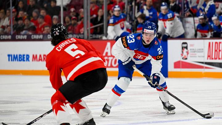 Jan 2, 2026; Minneapolis, Minnesota, USA; Slovakia forward Jakub Dubravik (23) controls the puck as Canada defensemen Carson Carels (5) defends during the first period in the quarterfinals of the 2026 IIHF World Junior Championship at 3M Arena. Mandatory Credit: Nick Wosika-Imagn Images