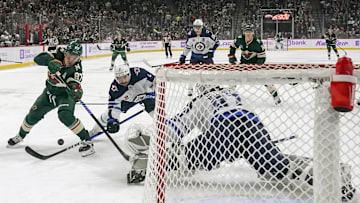 Nov 25, 2024; Saint Paul, Minnesota, USA;  Winnipeg Jets defenseman Neal Pionk (4) poke-check the puck away from Minnesota Wild forward Kirill Kaprizov (97) during the first period at Xcel Energy Center. Mandatory Credit: Nick Wosika-Imagn Images