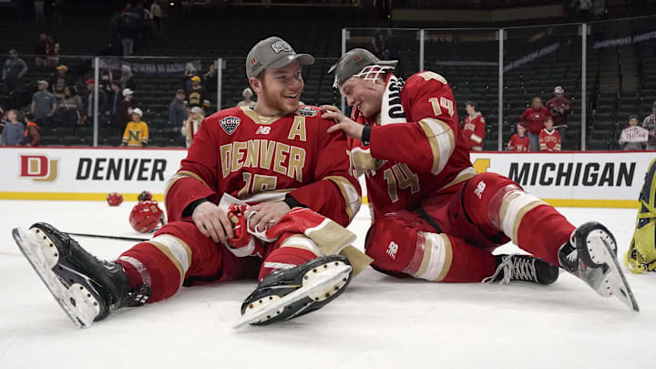 Apr 13, 2024; Saint Paul, Minnesota, USA; Denver Pioneers forward Carter King (15) and forward Rieger Lorenz (14) have a moment after defeating the Boston College Eagles for the national championship at the 2024 Frozen Four college ice hockey tournament at Xcel Energy Center. Mandatory Credit: Nick Wosika-Imagn Images