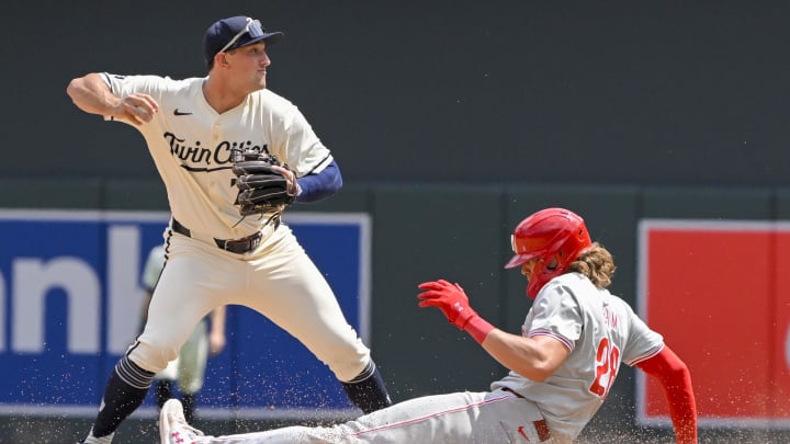 Jul 24, 2024; Minneapolis, Minnesota, USA;  Minnesota Twins infielder Brooks Lee (72) throws over Philadelphia Phillies infielder Alec Bohm (28) after forcing him out by during the seventh inning at Target Field. Mandatory Credit: Nick Wosika-USA TODAY Sports