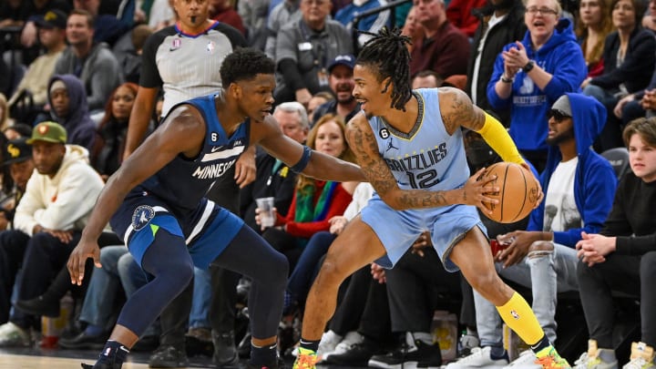 Nov 30, 2022; Minneapolis, Minnesota, USA;  Memphis Grizzlies guard Ja Morant (12) protects the ball as Minnesota Timberwolves guard Anthony Edwards (1) defends during the second quarter at Target Center. 