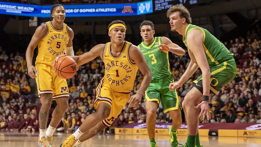 Jan 25, 2025; Minneapolis, Minnesota, USA; Minnesota Golden Gophers guard Isaac Asuma (1) drives to the basket as Oregon Ducks center Nate Bittle (32) defends during the first half at Williams Arena. Mandatory Credit: Nick Wosika-Imagn Images