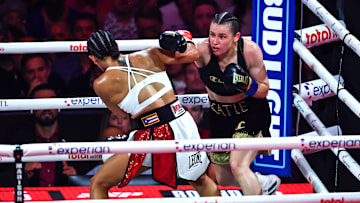 Katie Taylor (right) throwing a right hand against Amanda Serrano (left).