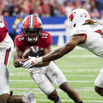 Sep 16, 2023; Indianapolis, Indiana, USA; Indiana Hoosiers running back Jaylin Lucas (12) runs the ball against Louisville Cardinals linebacker TJ Quinn (34) in the second half at Lucas Oil Stadium.