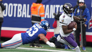 East Rutherford, NJ -- December 15, 2024 -- Darius Muasau of the Giants tries to tackle Lamar Jackson of the Ravens in the first half. The Baltimore Ravens came to MetLife Stadium to play the New York Giants.