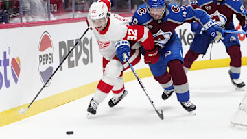 Mar 25, 2025; Denver, Colorado, USA; Detroit Red Wings center Marco Kasper (92) and Colorado Avalanche defenseman Samuel Girard (49) during the first period at Ball Arena. Mandatory Credit: Ron Chenoy-Imagn Images