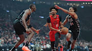 Apr 6, 2025; Portland, Oregon, USA; Portland Trail Blazers shooting guard Shaedon Sharpe (17) drives for the basket between San Antonio Spurs center Bismack Biyombo (18) and shooting guard Devin Vassell (24) during the first half at Moda Center. Mandatory Credit: Soobum Im-Imagn Images