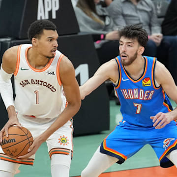 Jan 24, 2024; San Antonio, Texas, USA;  San Antonio Spurs center Victor Wembanyama (1) looks to pass in front of Oklahoma City Thunder forward Chet Holmgren (7) in the first half at Frost Bank Center. Mandatory Credit: Daniel Dunn-Imagn Images