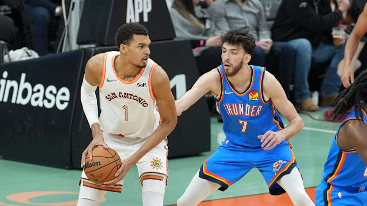 Jan 24, 2024; San Antonio, Texas, USA;  San Antonio Spurs center Victor Wembanyama (1) looks to pass in front of Oklahoma City Thunder forward Chet Holmgren (7) in the first half at Frost Bank Center. Mandatory Credit: Daniel Dunn-Imagn Images