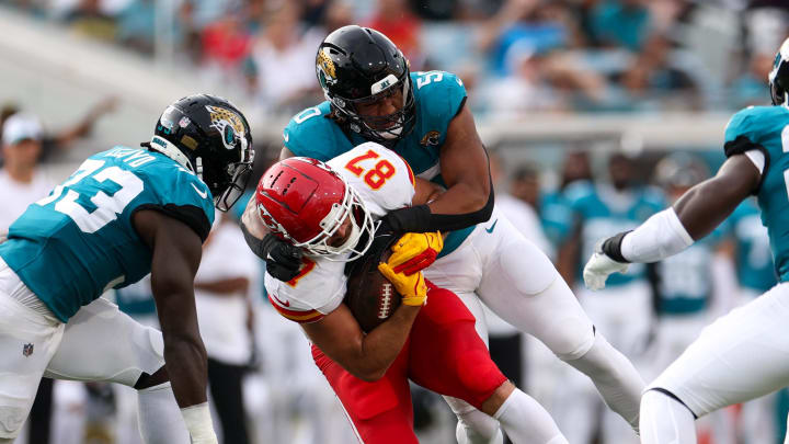 Aug 10, 2024; Jacksonville, Florida, USA; Kansas City Chiefs tight end Travis Kelce (87) is tackled by Jacksonville Jaguars defensive end Trevis Gipson (50) in the first quarter during preseason at EverBank Stadium. Mandatory Credit: Nathan Ray Seebeck-USA TODAY Sports