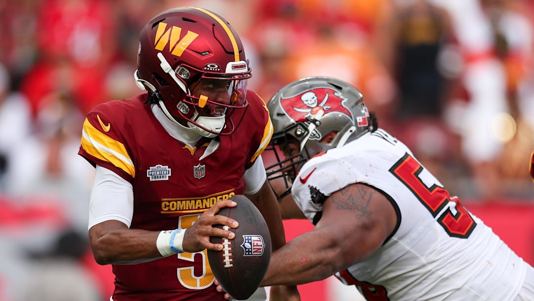 Sep 8, 2024; Tampa, Florida, USA; Washington Commanders quarterback Jayden Daniels (5) os pressured by Tampa Bay Buccaneers defensive tackle Vita Vea (50) in the third quarter at Raymond James Stadium. Mandatory Credit: Nathan Ray Seebeck-Imagn Images