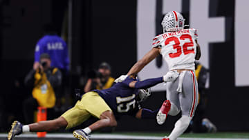 Jan 20, 2025; Atlanta, GA, USA; Notre Dame Fighting Irish cornerback Leonard Moore (15) attempts to tackle Ohio State Buckeyes running back TreVeyon Henderson (32) during the second half the CFP National Championship college football game at Mercedes-Benz Stadium. Mandatory Credit: Brett Davis-Imagn Images