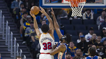 Jan 2, 2025; San Francisco, California, USA; Philadelphia 76ers center Joel Embiid (21) defends a shot by Golden State Warriors forward Trayce Jackson-Davis (32) during the first quarter at Chase Center. Mandatory Credit: John Hefti-Imagn Images