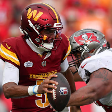 Sep 8, 2024; Tampa, Florida, USA; Washington Commanders quarterback Jayden Daniels (5) os pressured by Tampa Bay Buccaneers defensive tackle Vita Vea (50) in the third quarter at Raymond James Stadium. Mandatory Credit: Nathan Ray Seebeck-Imagn Images